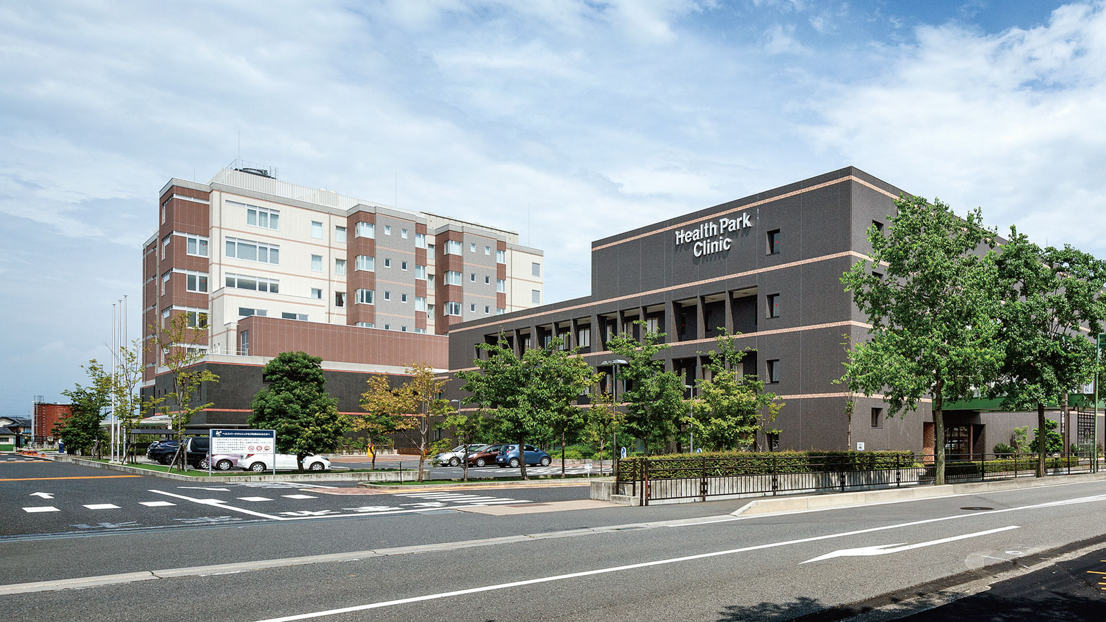 Health Park Clinic併設の介護施設外観。複合建物の全景を広角撮影した写真。